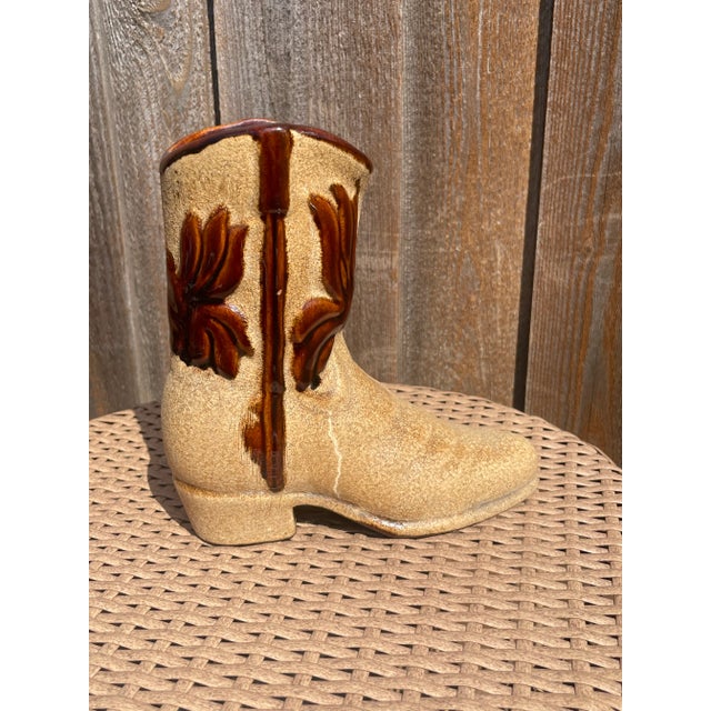 Textured tan ceramic boot shaped vase with brown glaze details.