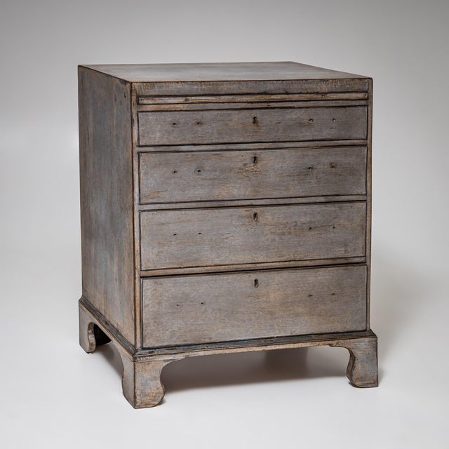 Chest of drawers with four drawers and a pull-out writing slide. Resting on shaped bracket feet, newly painted in dark...