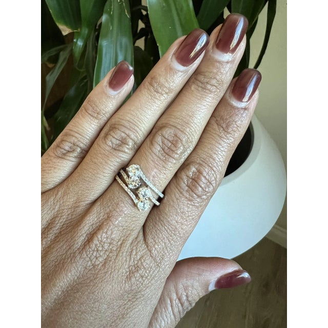 This ring features two Round Cut White Diamonds with a primary carat weight of 0.55 Carats and the surrounding diamonds...