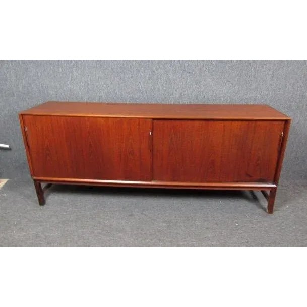 This Mid-Century Modern style credenza offers plenty of storage behind sliding doors, with multiple shelves and slide out...
