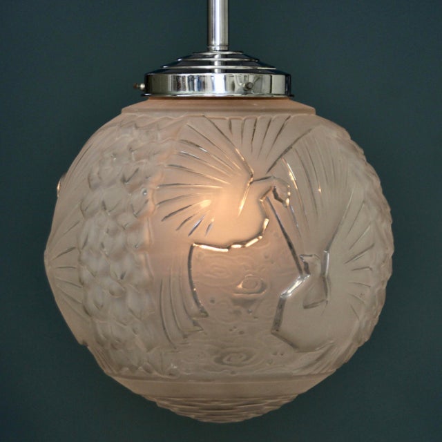 This large ceiling light with a peacock motive was produced by the manufacturer Muller Frères in Luneville circa 1925....