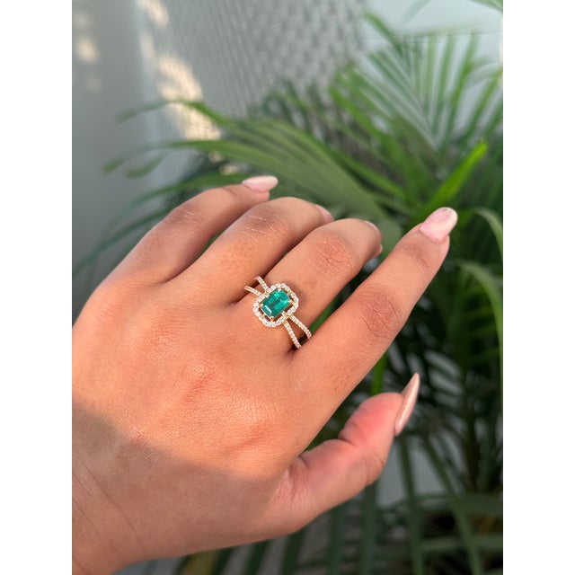 This striking 1.06 carat emerald-cut emerald and diamond split-shank ring is crafted in 14K yellow gold. The emerald...