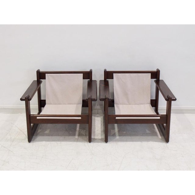 Pair of midcentury armchairs with veneered walnut wood frame and beige canvas fabric seats. Made in Brazil circa 1960s....