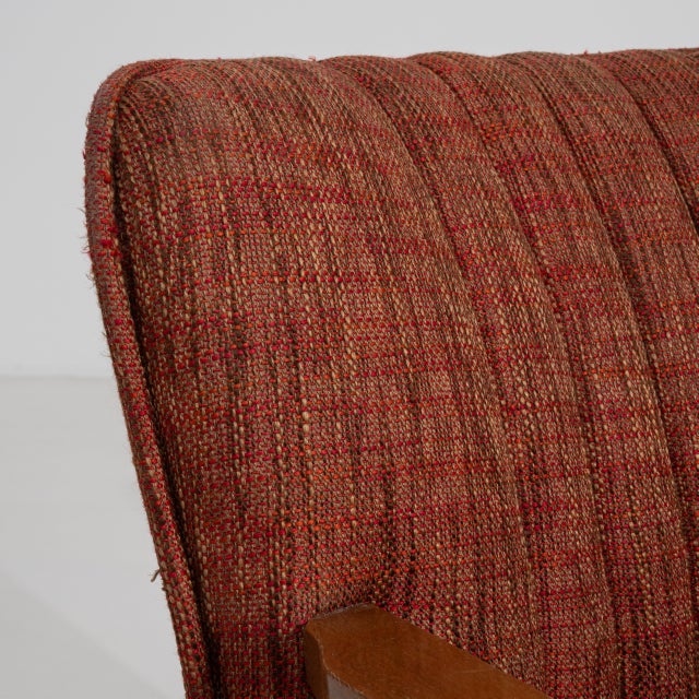 A pair of mid-century modern armchairs with simple wooden frames and upholstered seats. The design emphasizes clean lines...