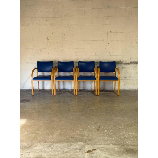 These four armchairs feature curved wooden frames paired with vibrant blue upholstery. Originating from Denmark, they...