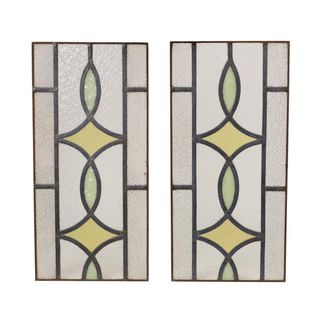 A lovely set of two vintage, narrow stained-glass panels featuring a colorful geometric pattern—essentially stained-glass...