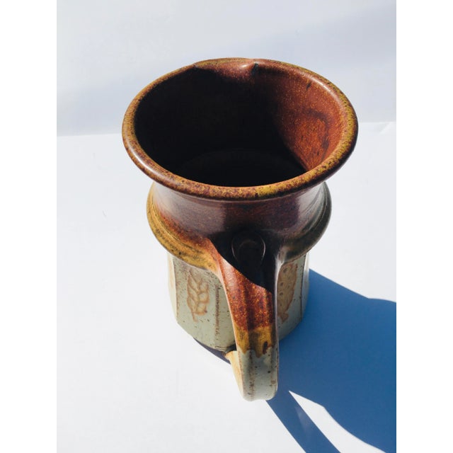 This hand crafted pottery pitcher is fired stoneware. The signature is an impressed mark (see photo) The condition is perfect