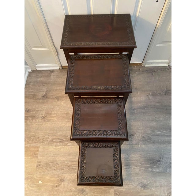 This is a good quality Chinese Rosewood nest of four carved graduating tables. The tables feature various oriental scenes...