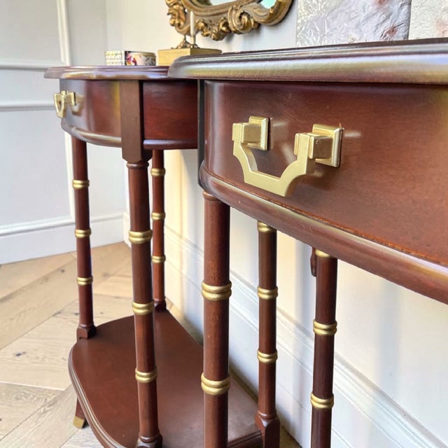 A stunning pair of cherry faux bamboo bedside tables featuring warm wood tones, sculptural lines, and hand-applied gold...