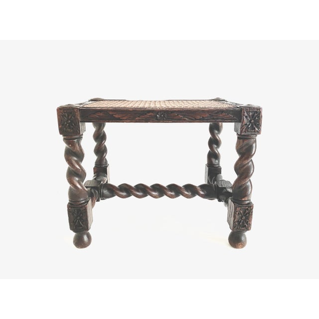 Antique Jacobean barley twist foot stool with intricate carved detail to the oak frame and caned seat. In very good...