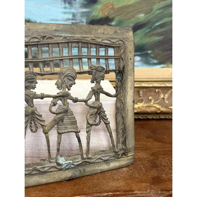 This Piece of primitive decorative wall art depicts a tribal dancing scene and is possibly brass I’m material. This Piece...