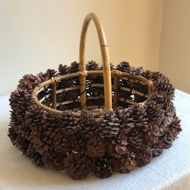 Offering a beautiful hand-crafted Adirondack-style pine cone basket. This luxurious basket features a bamboo structural...