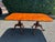 Stately and versatile warm walnut dining table having gorgeous grain and visible old world nailheads on top, with two...