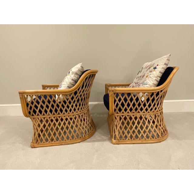 Pair of rattan chairs. Late 20th century. Listing includes the blue corduroy cushions and decorative throw pillows.