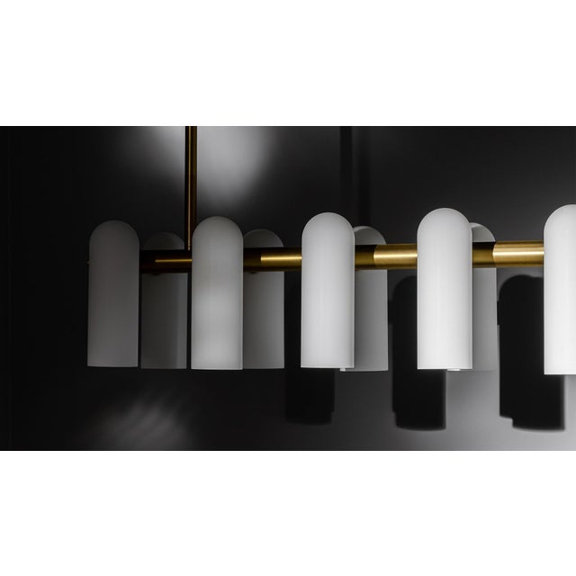 A colonnade of light sources. This delicate engine of frosted glass generates a luminous environment while contrasting...
