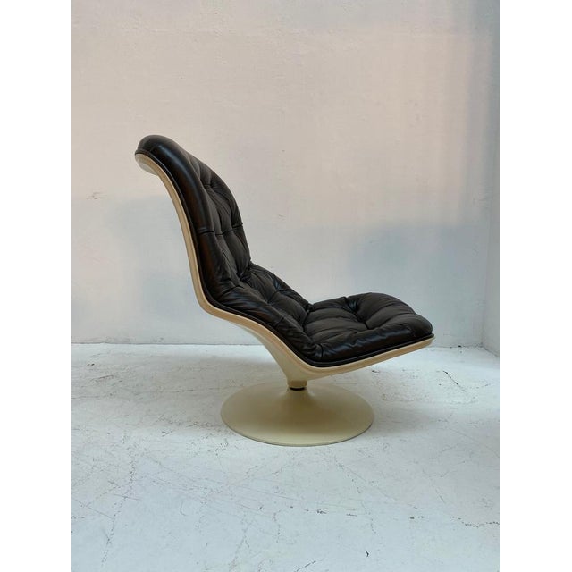 A vintage "Shelby" lounge chair by Georges Van Rijk for Beaufort, 1970s. Cream fibreglass shell with black leather...