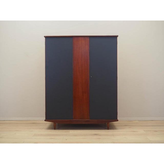The wardrobe was made in the 1960s in Denmark. The structure is covered with teak veneer. The legs are made of solid wood....