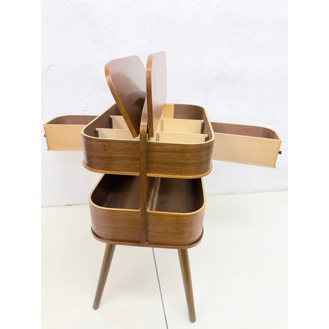 Used sewing box from the 1950s/60s with fold-out compartments in Scandinavian style. Curved plywood with teak (or walnut)...
