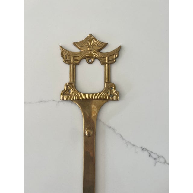 This brass plate or art hanger has a pagoda design at the top and fluted design on the bottom. There are two knobs for two...