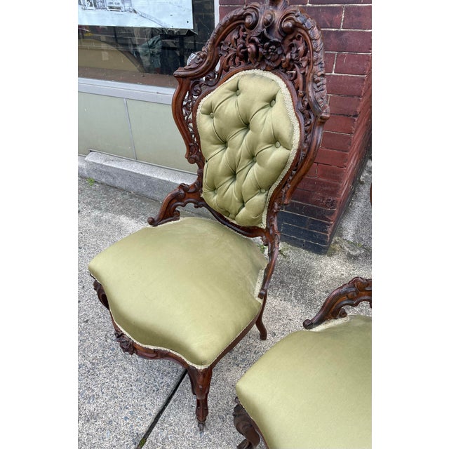 Here is a fantastic ornately carved and cut-out pair of Victorian slipper chairs made in the style of John Henry Belter...