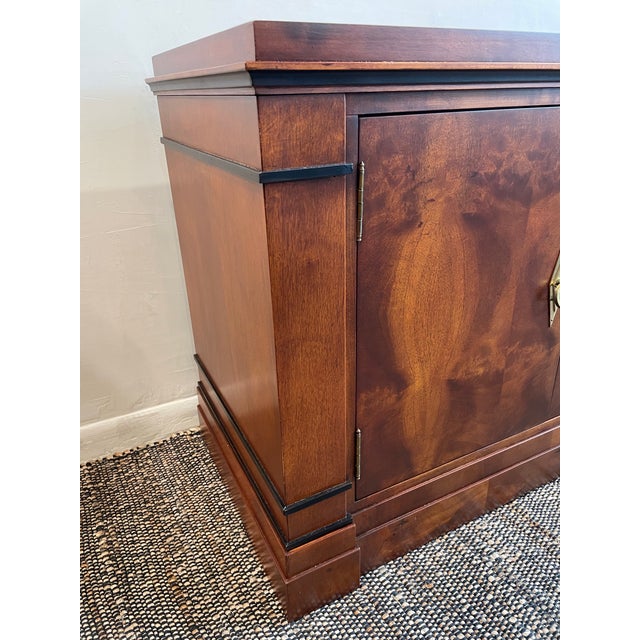This handsome four-door credenza has a rich, warm wood finish and a strong. Four brass ring pulls set within elongated...