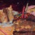This artwork captures a moment of indulgence, featuring a partially consumed cake on a vibrant, chaotic table. The soft...