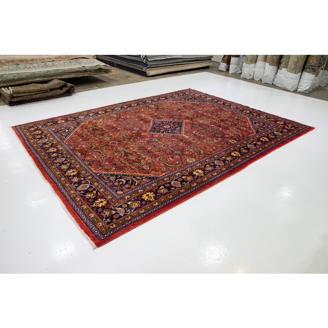 Beautiful vintage Persian Mahal hand-knotted wool rug with a red field. This piece has a navy blue frame and multicolor...