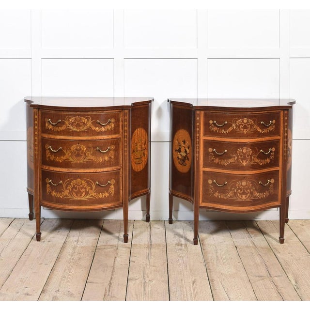 A near pair of Edwards and Roberts chest of drawers in the Hepplewhite taste. The shaped tops, one with a serpentine...