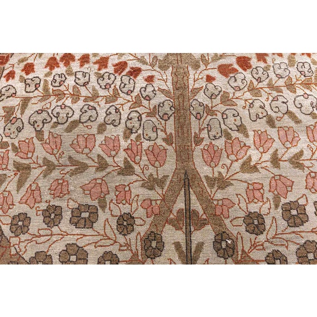 A hand-knotted wool antique Persian Tabriz rug dating back to circa 1920. The main field features florals, vines, trees...
