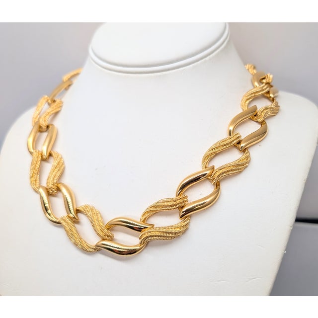 1992 goldtone textured and smooth link necklace with fold over clasp. Marked "Napier" in script with the utility patent...