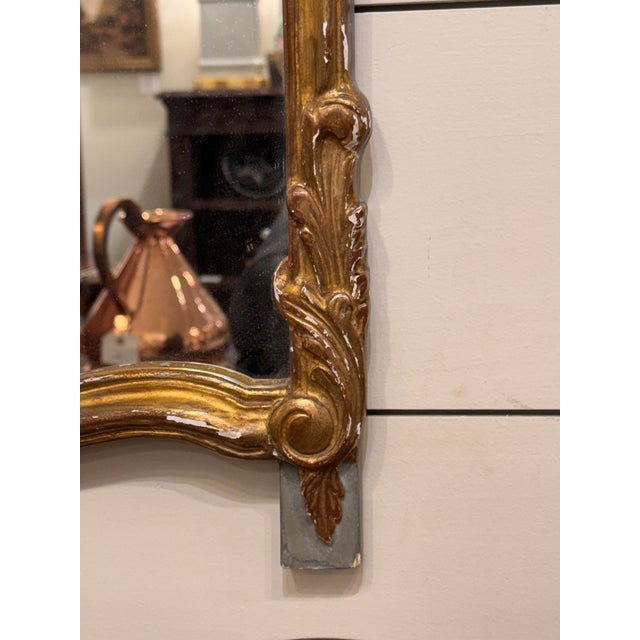 Antique French gilt gesso wall mirror in Rococo style. It features an ornate, flowing giltwood border with C-shapes,...