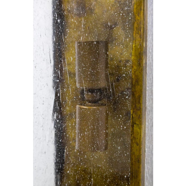Geometric wall sconces from the mid-20th century, with handmade brass structures, holding clear, seeded glass on the front...
