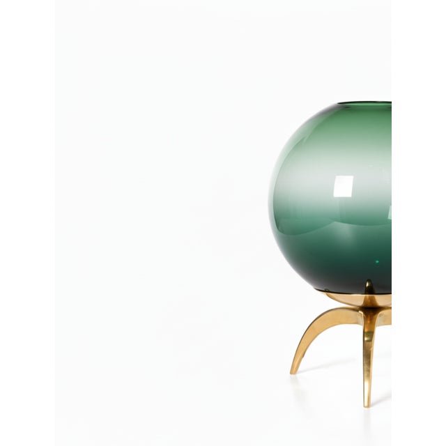 A chic Italian console lamp, newly made. Each lamp has a green ombre murano glass globe that sits atop a brass tripod base.