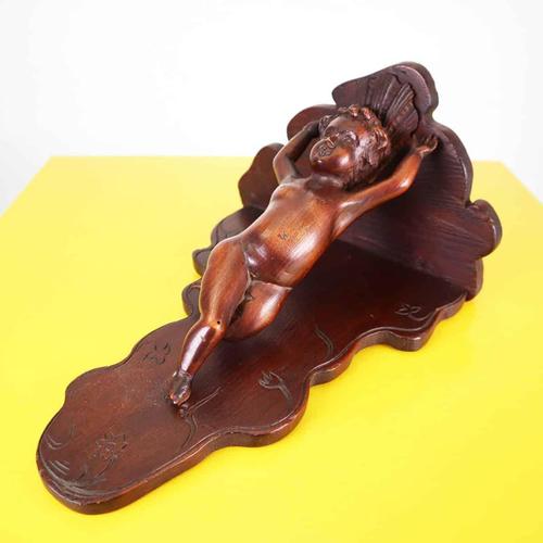 Item : this finely crafted wooden shelf features a detailed carving of a cherub. Featuring a curved design and carved...