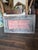 Raised metal drink Coca-Cola sign fragment mounted in a distressed barn wood frame
