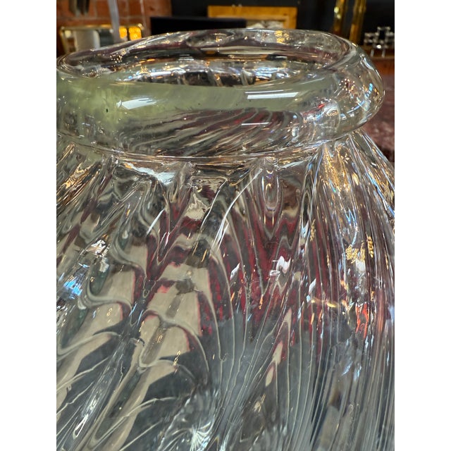 Elegant handblown clear glass vase features a striking spiral twist design that wraps gracefully around its rounded form,...
