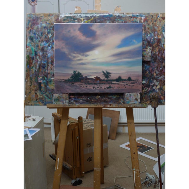 This oil painting captures a solitary structure set against a vast, open landscape under a dramatic sky filled with soft...