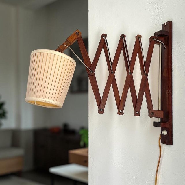Vintage wooden scissor wall lamp featuring an adjustable accordion-style extension arm. The articulated wooden mechanism...