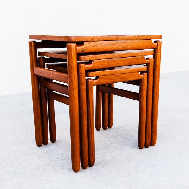 A newly refinished set of three floating top teak nesting tables, made in Denmark c. 1960s. Each table features a...