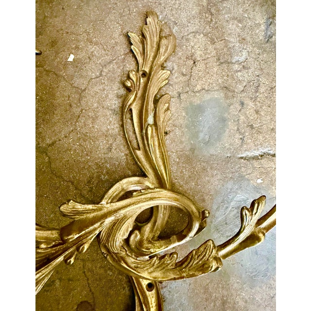 Gorgeous vintage gilt bronze finish Louis XV-style twin-light wall sconce featuring ornate foliate forms and stylized...