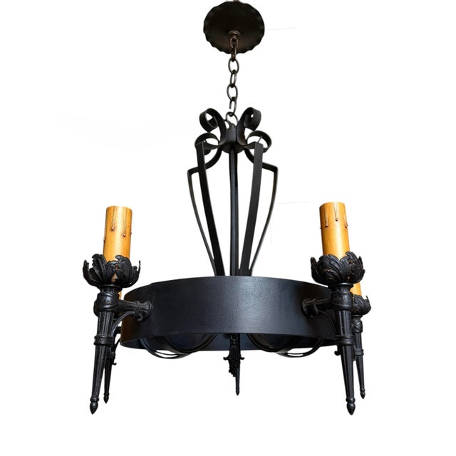 This is a Spanish Revival wrought iron chandelier, dating from the 1920s and featuring rustic candle-style lights. It...
