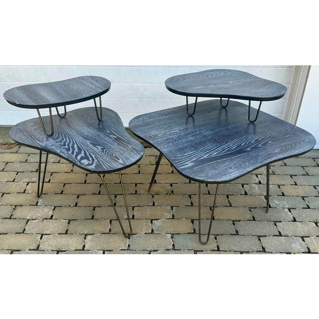 Great asymmetrical pair of 1950s vintage two-tear side tables. Cerused oak organic shape tops, iron hairpin legs. Smaller...