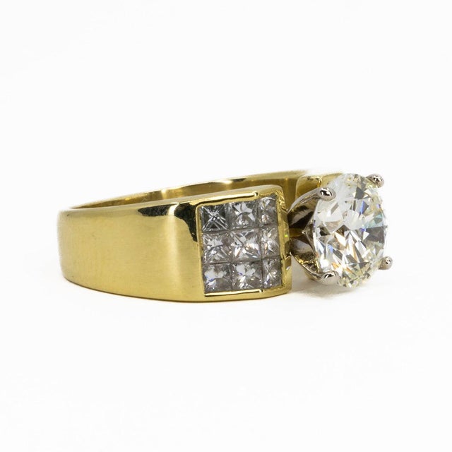 18k Ring with one GIA certified (#2215963949) K color VS1 clarity 2.17 carat round brilliant and 18 princess cut diamonds...