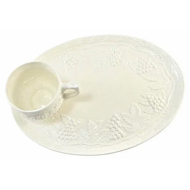 Set of four repousse grape pattern trays with matching cups. Trays, 10.25” L x 7.5” W x .5” H; cups, 4” L x 3” W x 2.25”...