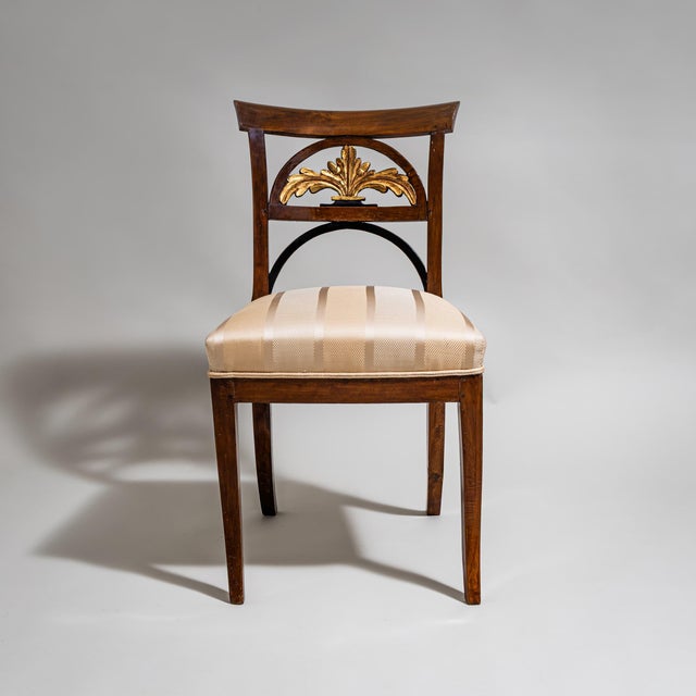 Biedermeier side chair with an upholstered seat and a stained beechwood frame. The unusually designed backrest features...