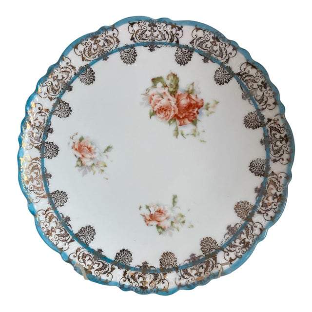 A set of 9 porcelain plates made by Imperial China, Austria c. 1900. Each is edged in blue with red/orange roses and a...