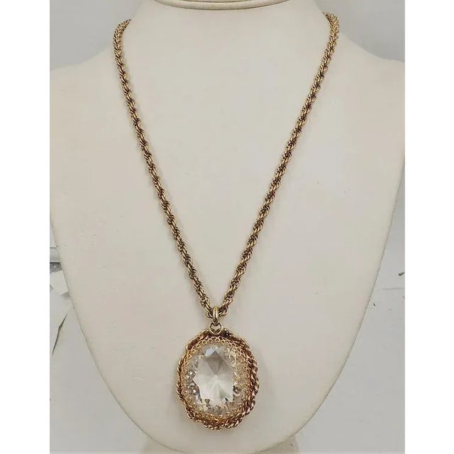 This is part of Chairish’s Costume Jewelry assortment. 1950s goldtone filigree large faceted unfoiled open-backed clear...