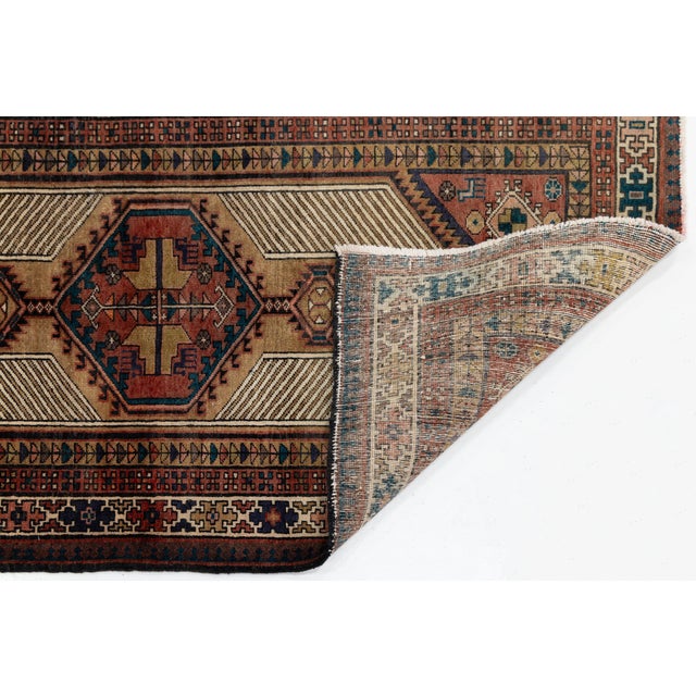 Exuding timeless character and artistic authenticity, this hand-knotted vintage Kurdish runner rug brings refined warmth...