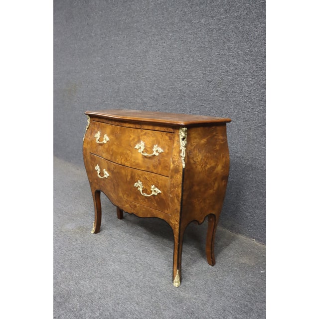 Italian-style commode featuring a curved bombe form with beautifully figured burl walnut veneer. This piece has two...