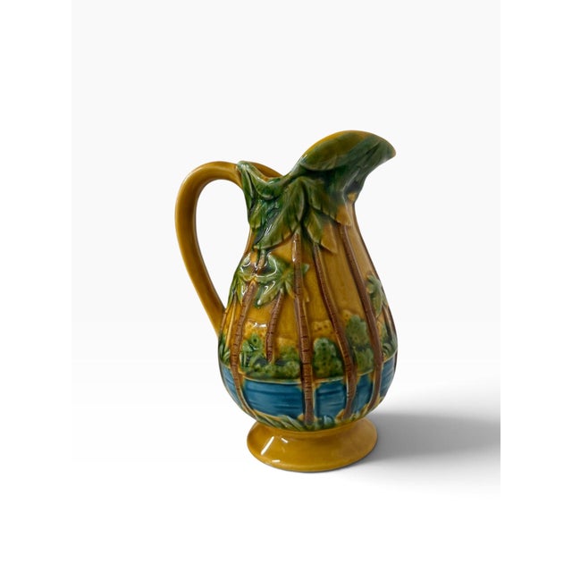 Vintage Florida souvenir palm tree pitcher. Blue and green on a back drop of saffron. Measures 5” x 3.5” x 6”. No cracks,...
